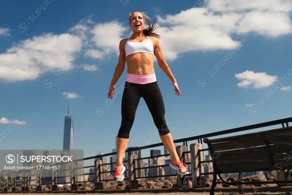 USA, New Jersey, Jersey City, Woman in sportswear jumping outdoors