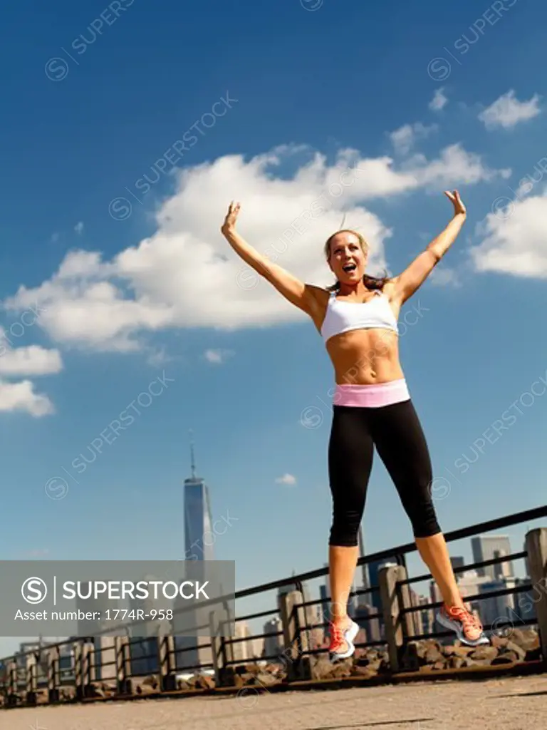 USA, New Jersey, Jersey City, Woman in sportswear jumping outdoors