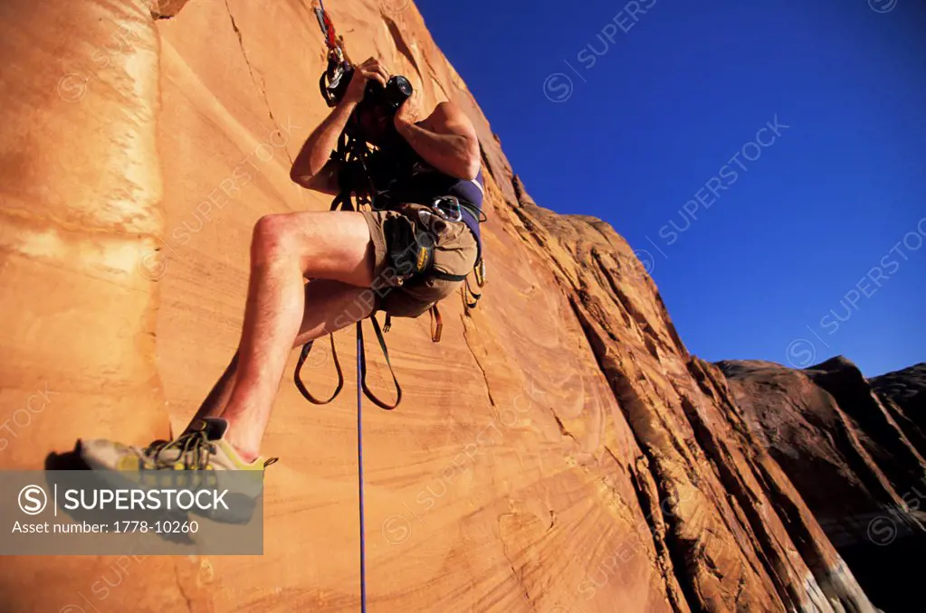 A man with a camera, climbing