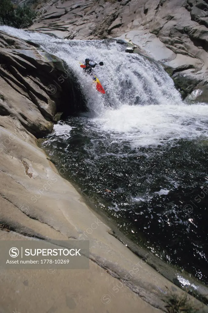 A man drops a waterfall in a kayak