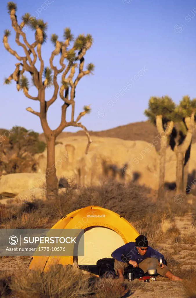 A man brews up some coffee early in the morning while camping