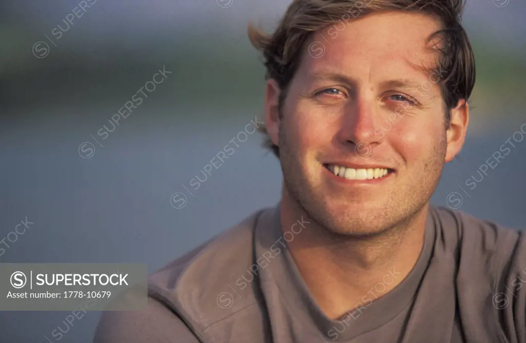 A headshot of a man on vacation in a tropical resort