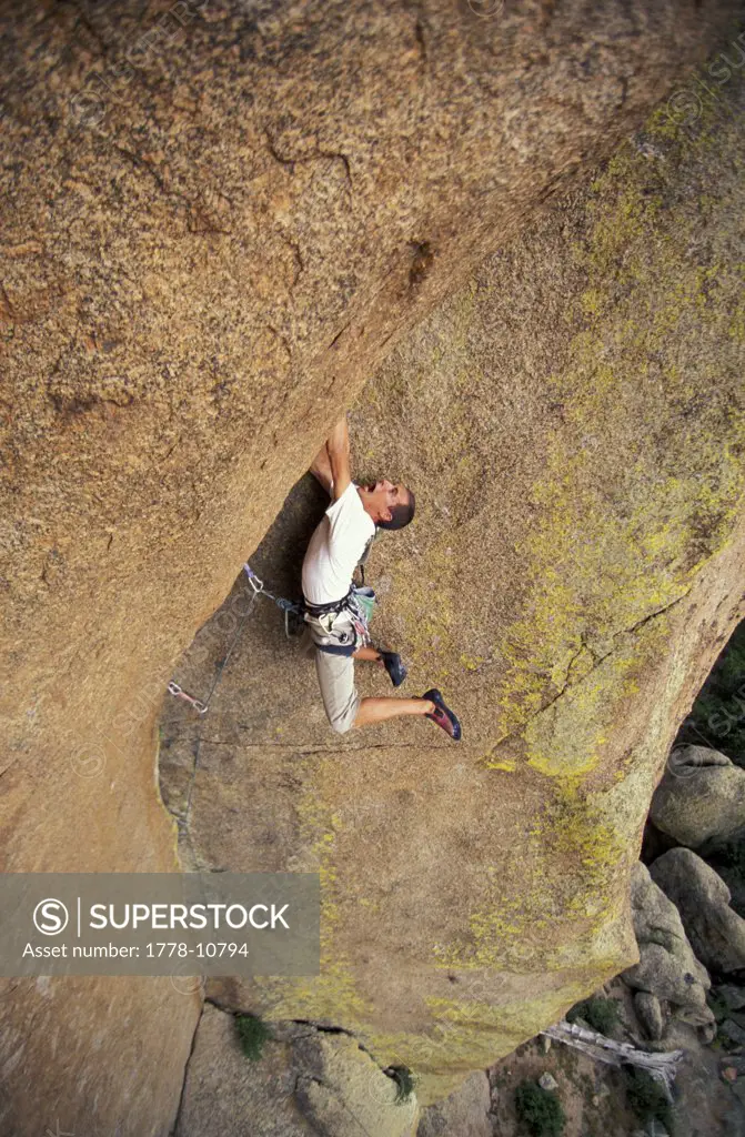 A man lead climbs a difficult overhanging route