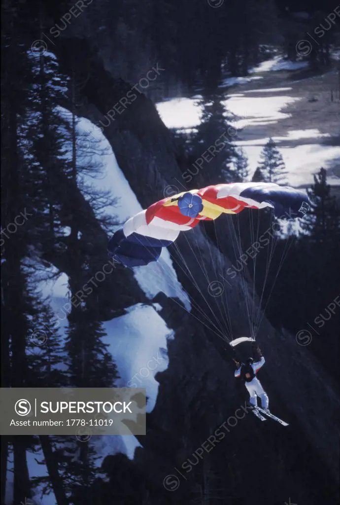 Ski-BASE jumper descending via parachute, near Lake Tahoe