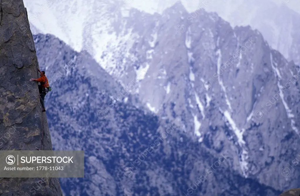 A male rock climber in an alpine setting