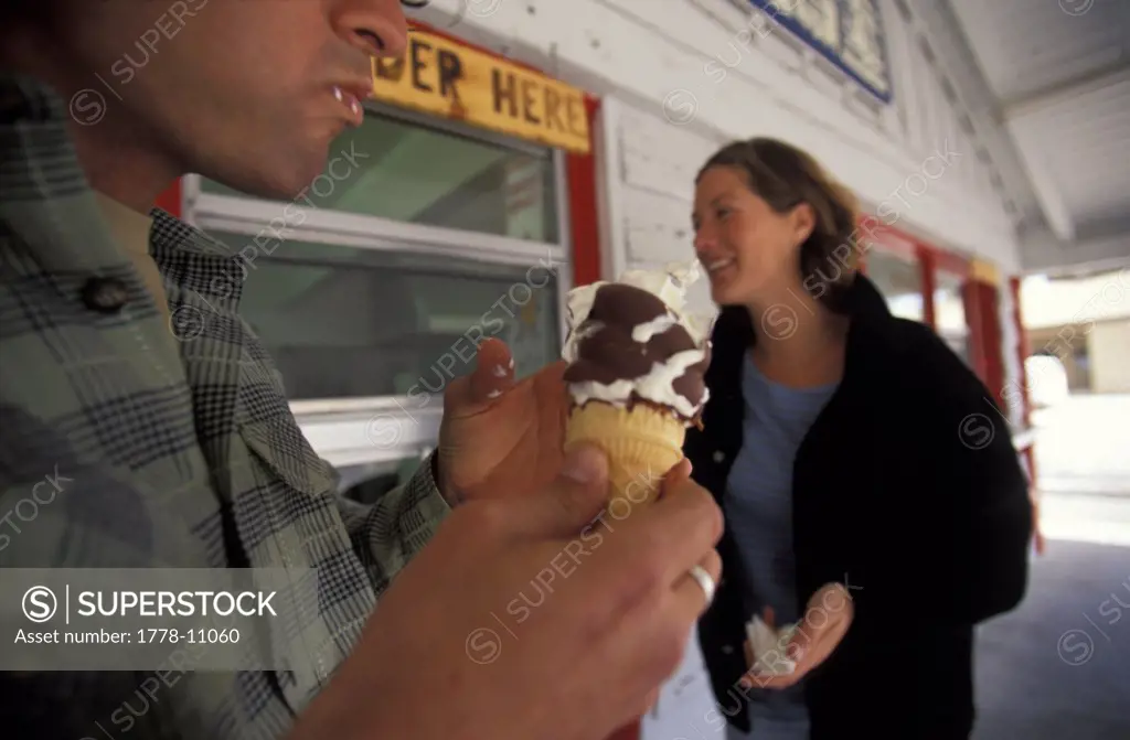 A man and woman enjoy chocolate-dipped soft serve