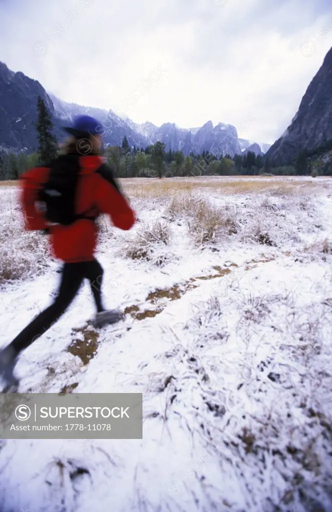 A woman trail running on a snowy winter day
