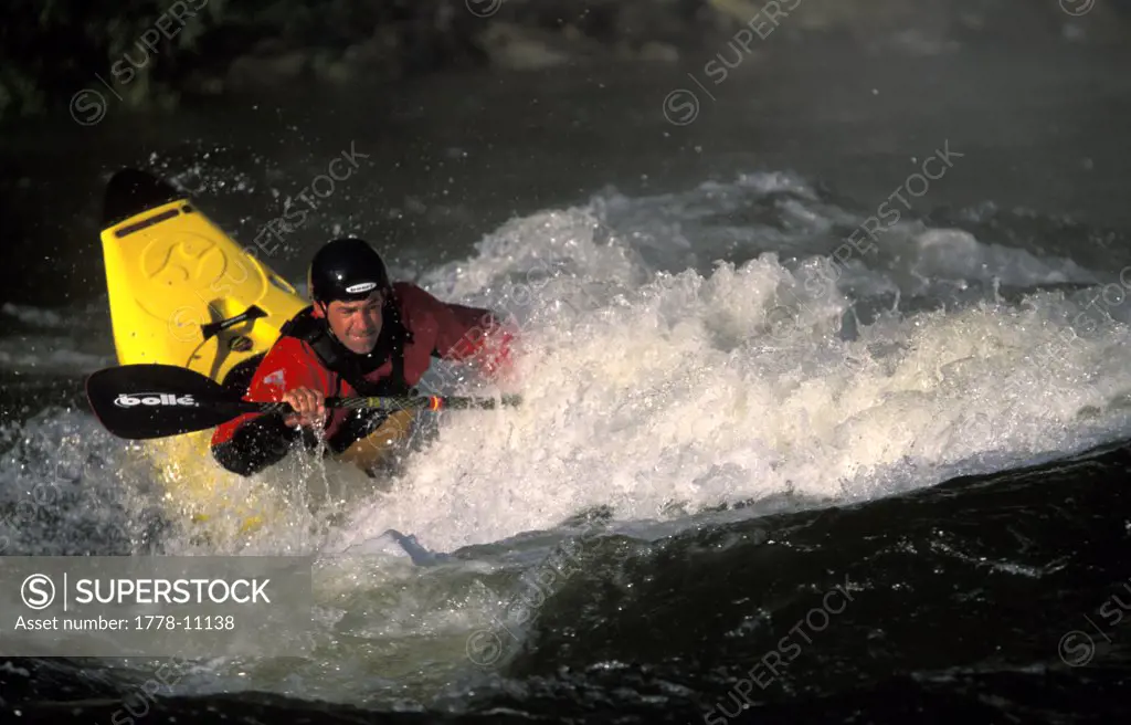 A man surfing whitewater in a kayak