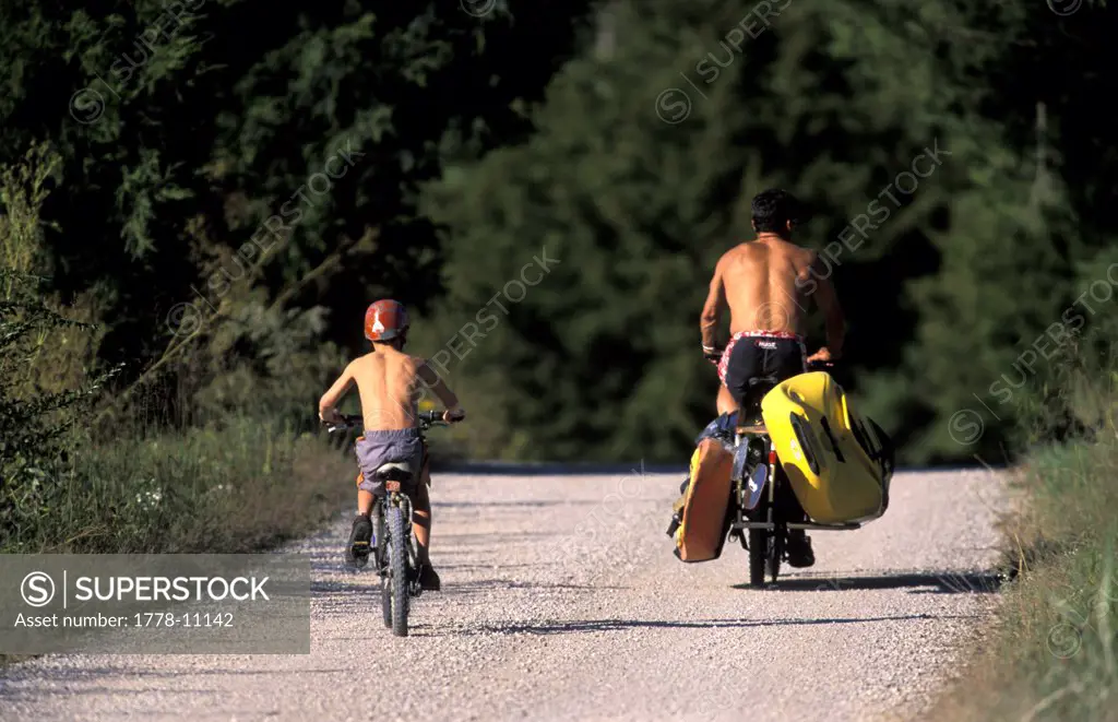 A father and son ride their bikes to go kayaking