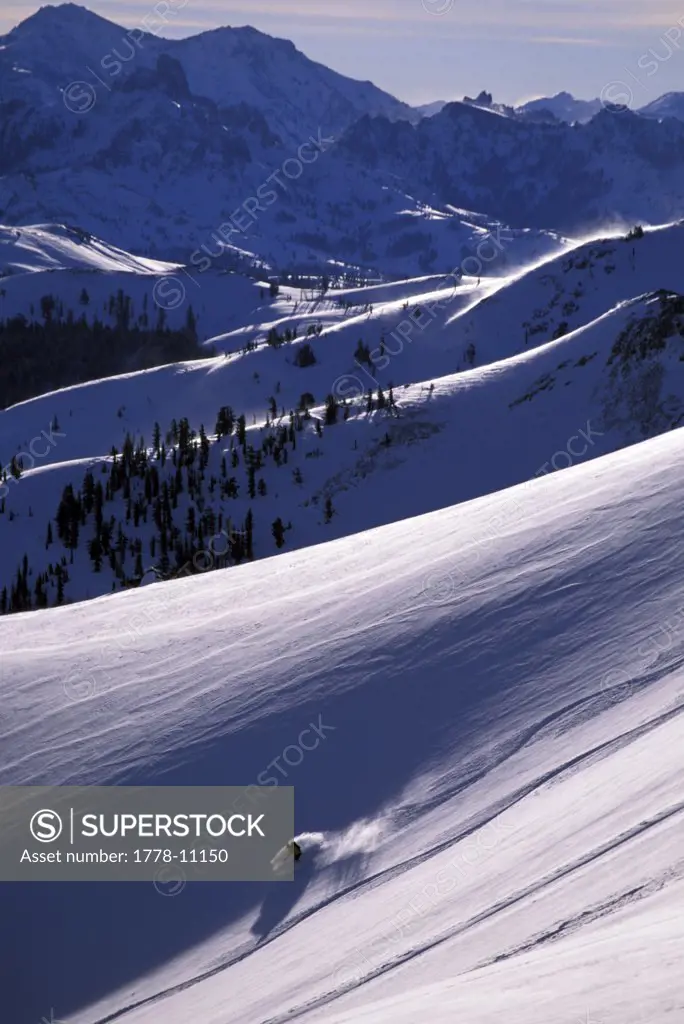 A man backcountry skiing on a bluebird powder day
