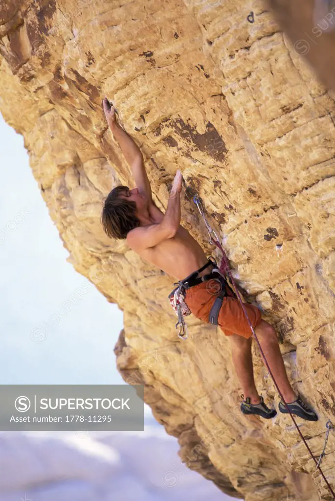 A male rock climber climbing in the desert on an overhanging route