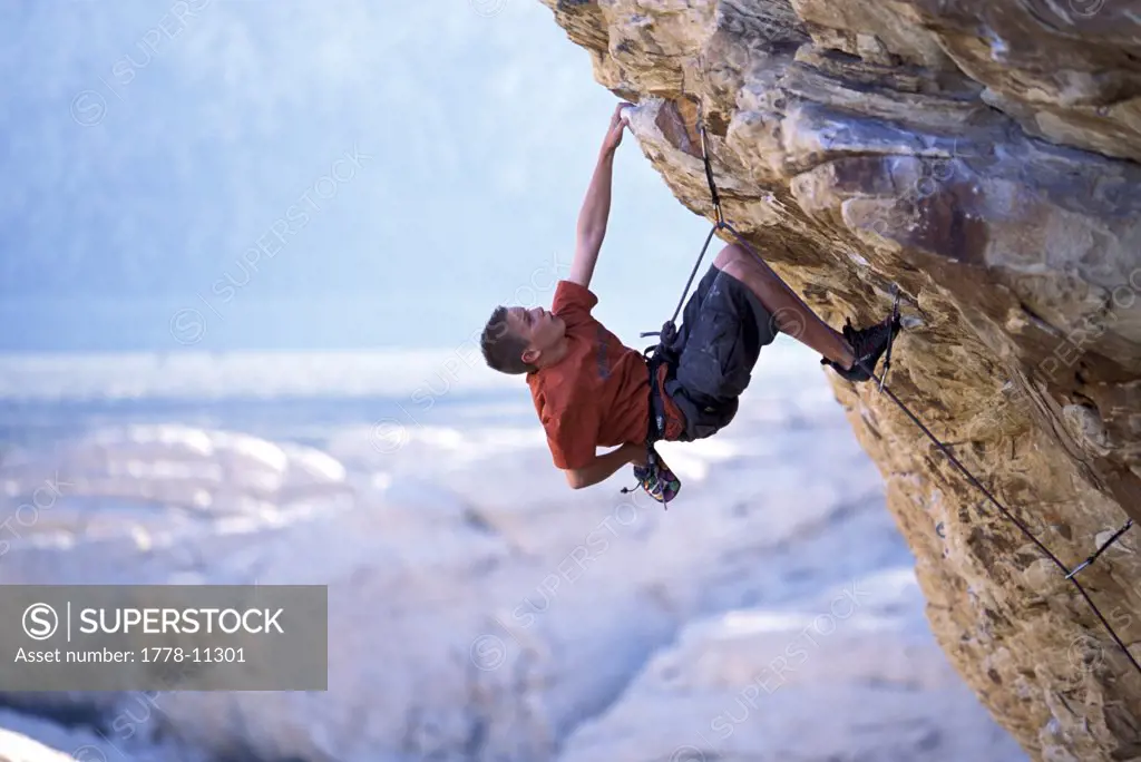 A young male climber on an overhanging route in the desert