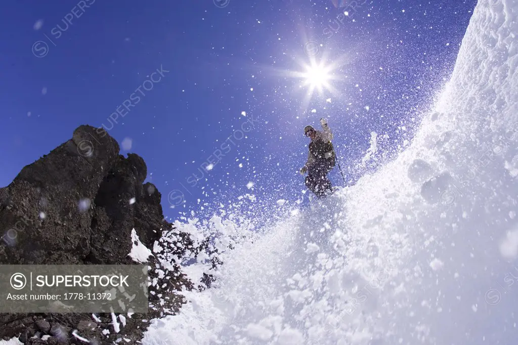 Young man dropping into couloir at Kirkwood ski resort near Lake Tahoe, CA