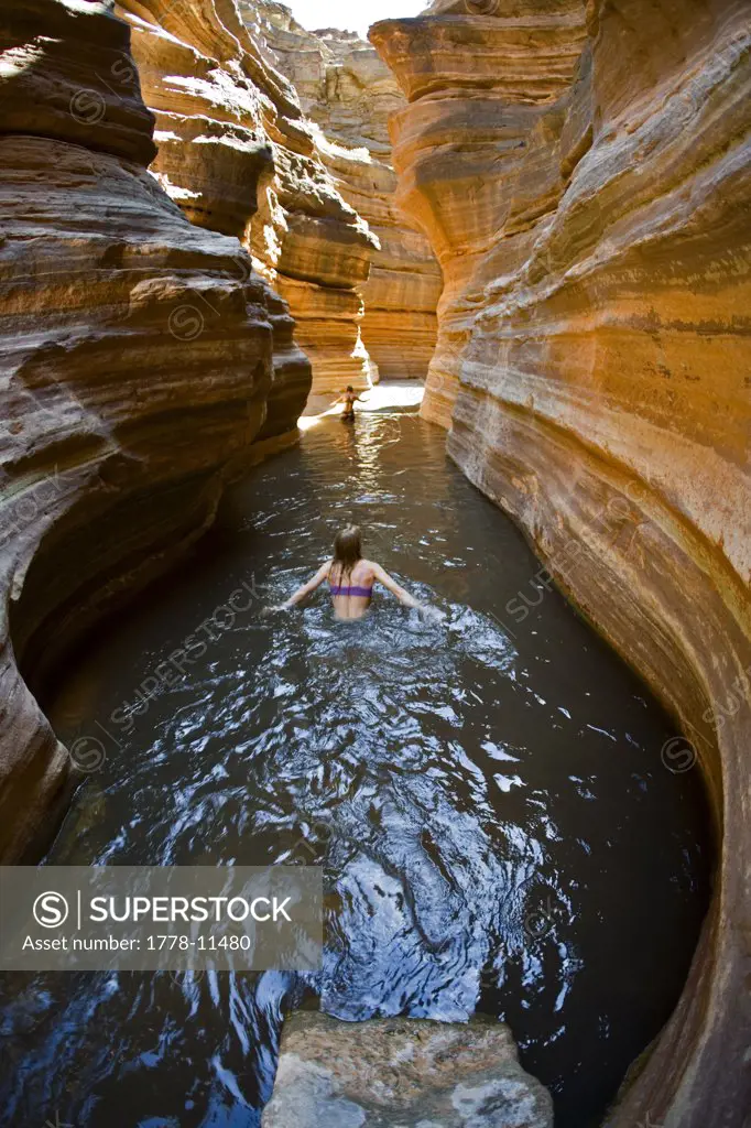 woman wading through pool in desert canyon, Grand Canyon, Arizona