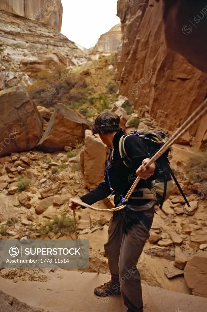man rappelling into desert canyon, Robbers Roost, Utah