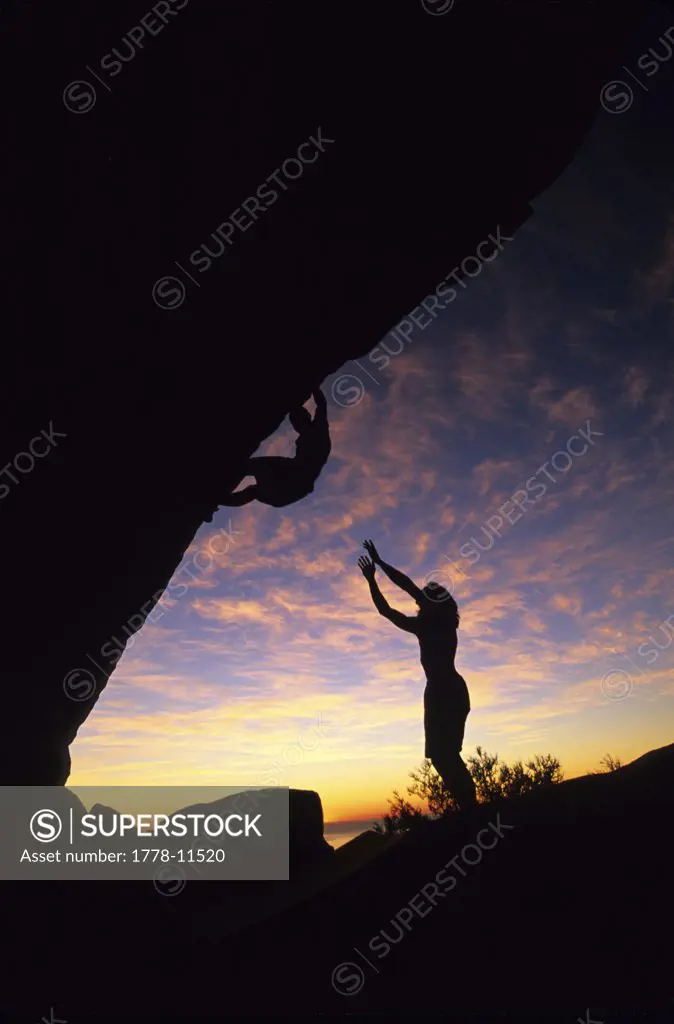 Two boulderers at sunset