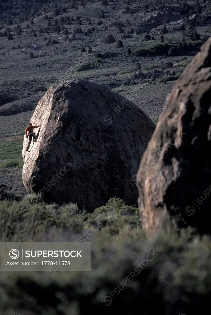 A man bouldering in the desert on a cool fall day
