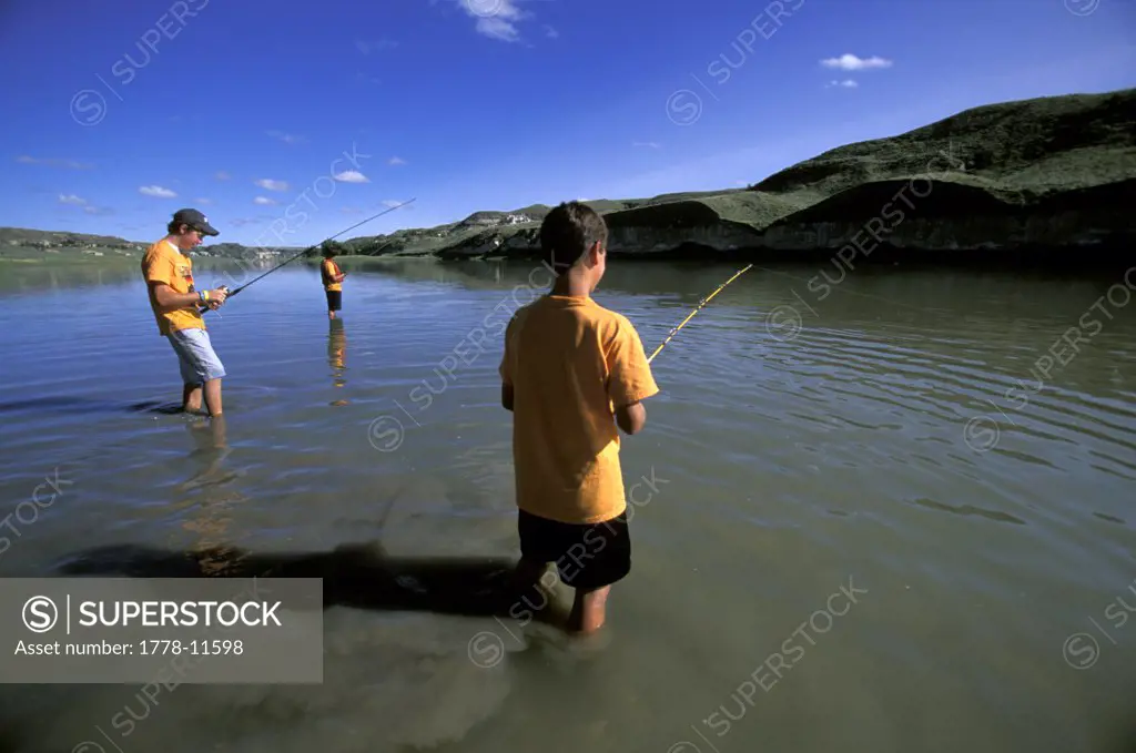 A group of boys fishing in a river