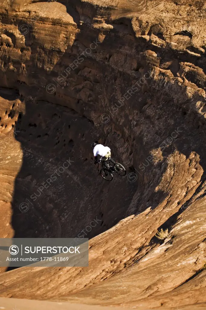 Man mountain biking down steep rock in Moab, Utah