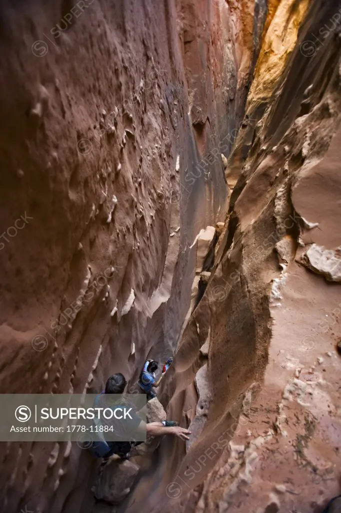 Three people descending a slot canyon, Utah