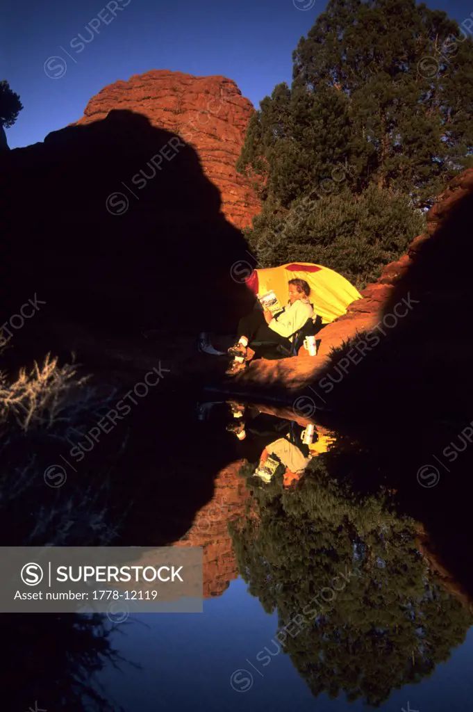Woman camping at the edge of a pond, Paria Canyon-Vermillion Cliffs Wilderness, Arizona