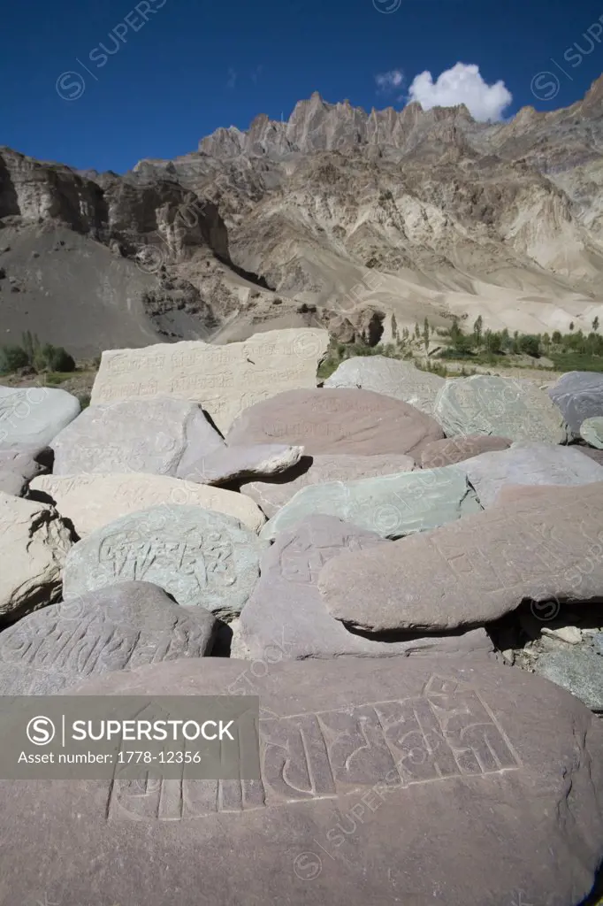 Buddhist mani stones line trail on popular trekking route in Ladakh, northern India