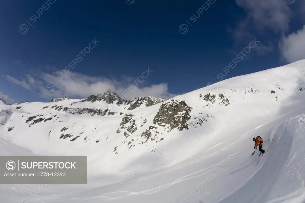Man telemark skis down hill in Canada backcountry near Alaska Canada border
