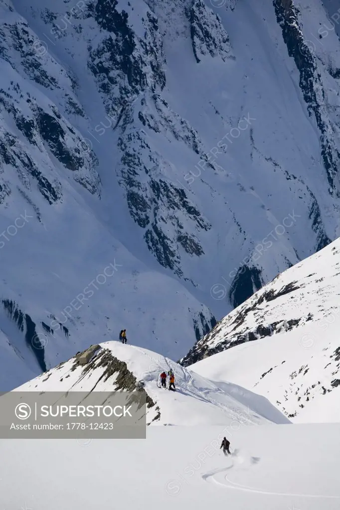 Man telemark skis down hill in Alaska backcountry near Alaska Canada border