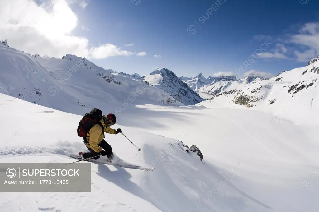Man telemark skis down hill in Canada backcountry near Alaska Canada border