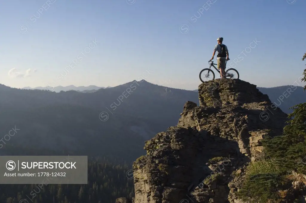 A mountain biker on a spire at sunset on Barker Pass above Lake Tahoe in California