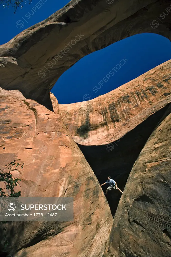 A man below an arch, Moab, Utah