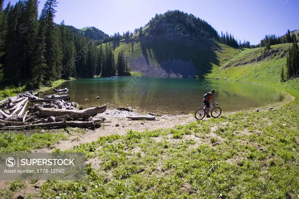 Woman mountain biking near lake, Wyoming