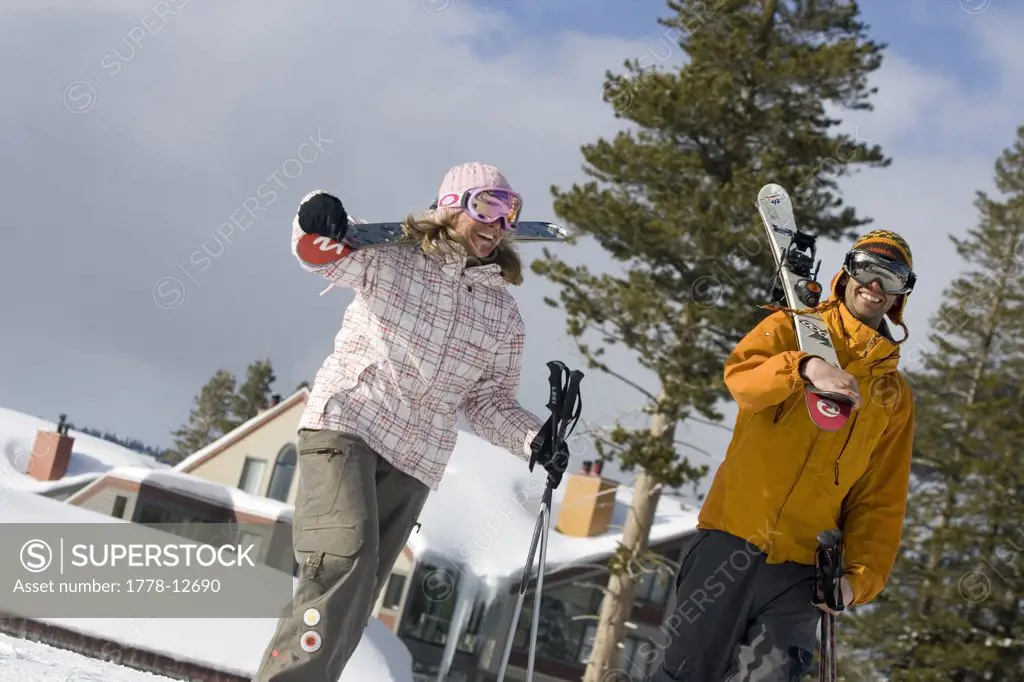 Young woman and man carrying skiis at Kirkwood, California
