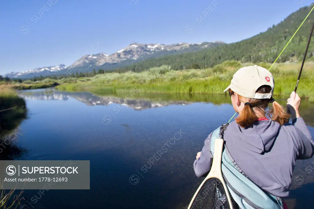 Young woman fly fishing the West Fork of the Carson River in Hope Valley, Lake Tahoe, California