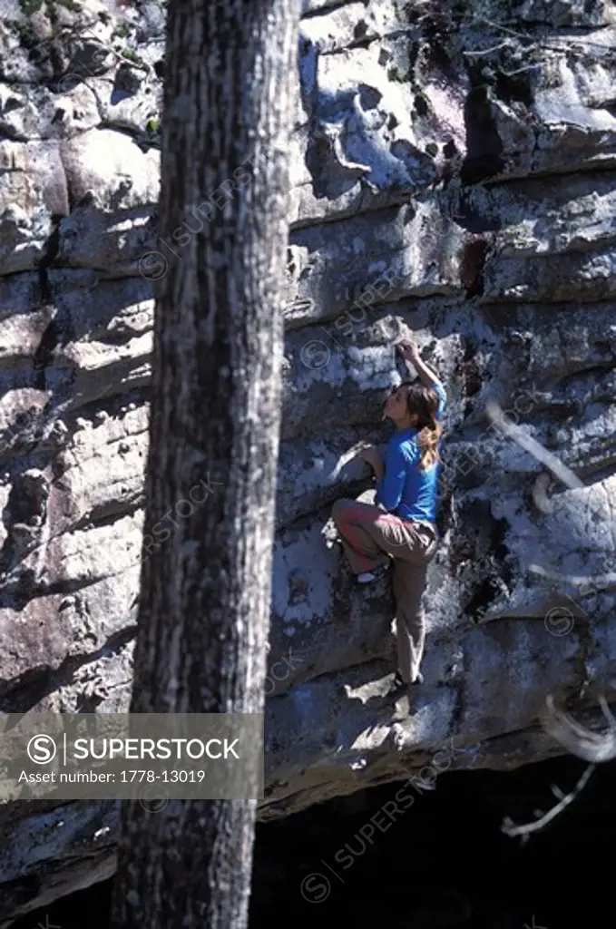 A female rock climber bouldering near Jasper, Arkansas