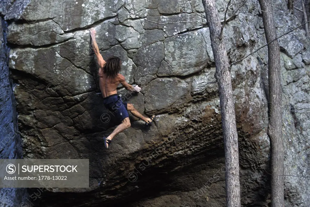Male rock climber bouldering without a shirt near Jasper, Arkansas