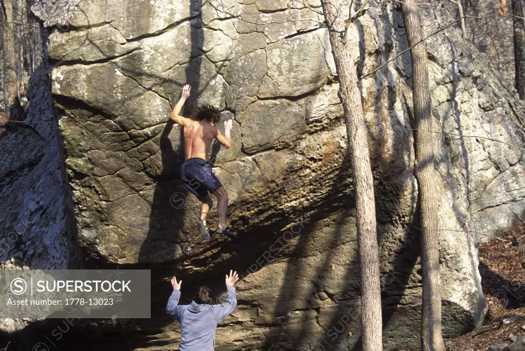 A man spots from below as a rock climber falls off his hold near Jasper, Arkansas