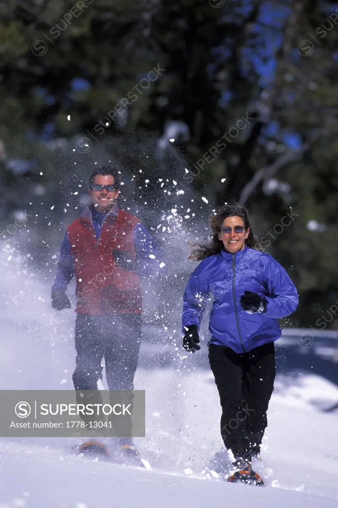 Man and a woman running on snowshoes in Lake Tahoe, California