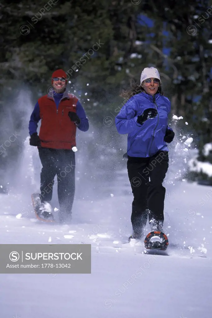 A man and a woman running on snowshoes in Lake Tahoe, California