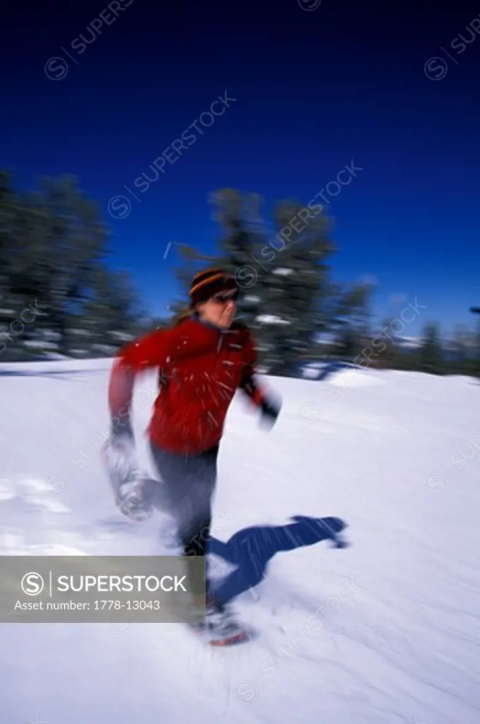 A woman running on snowshoes in Lake Tahoe, California (Blurred Motion)