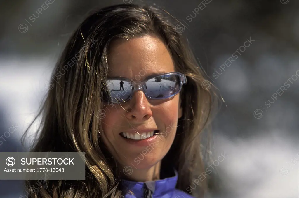 A woman in sunglasses smiles for a portait in Lake Tahoe, California
