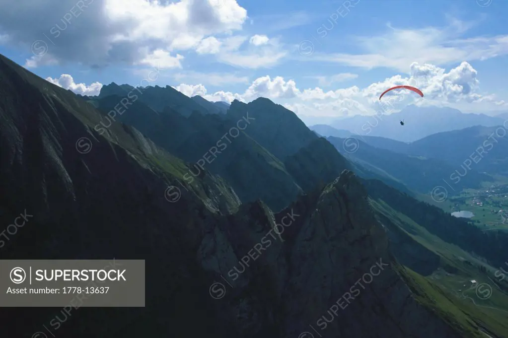 A paraglider flys above the Aravis valley, La Clusaz, French Alps, Haute Savoie