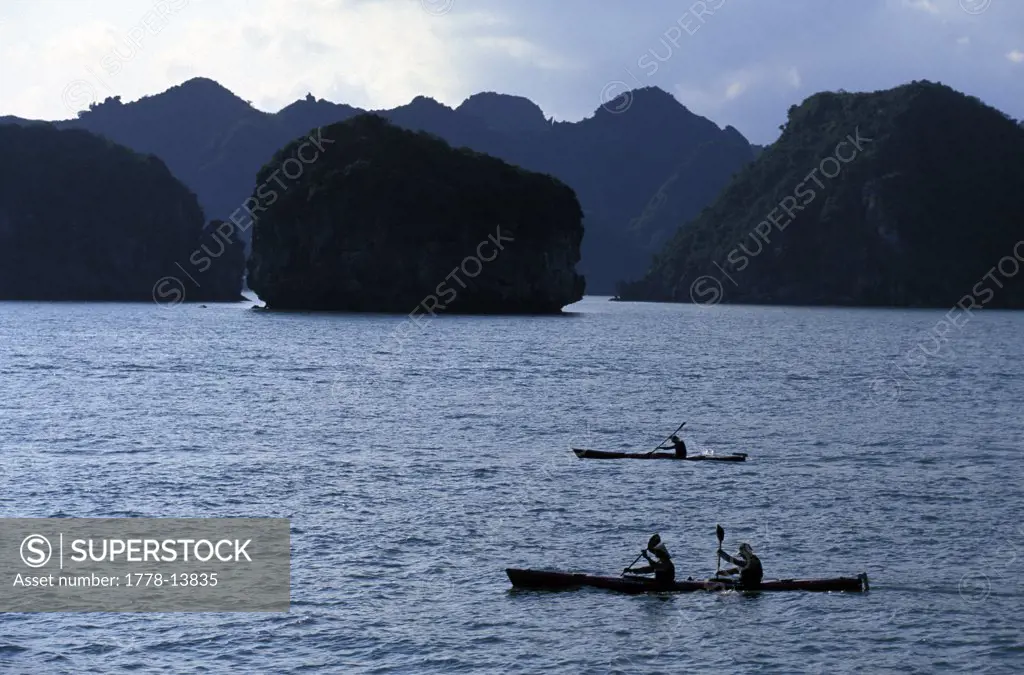 Racers paddle sea kayaks in Halong Bay during an adventure race in northern Vietnam (Silhouette)