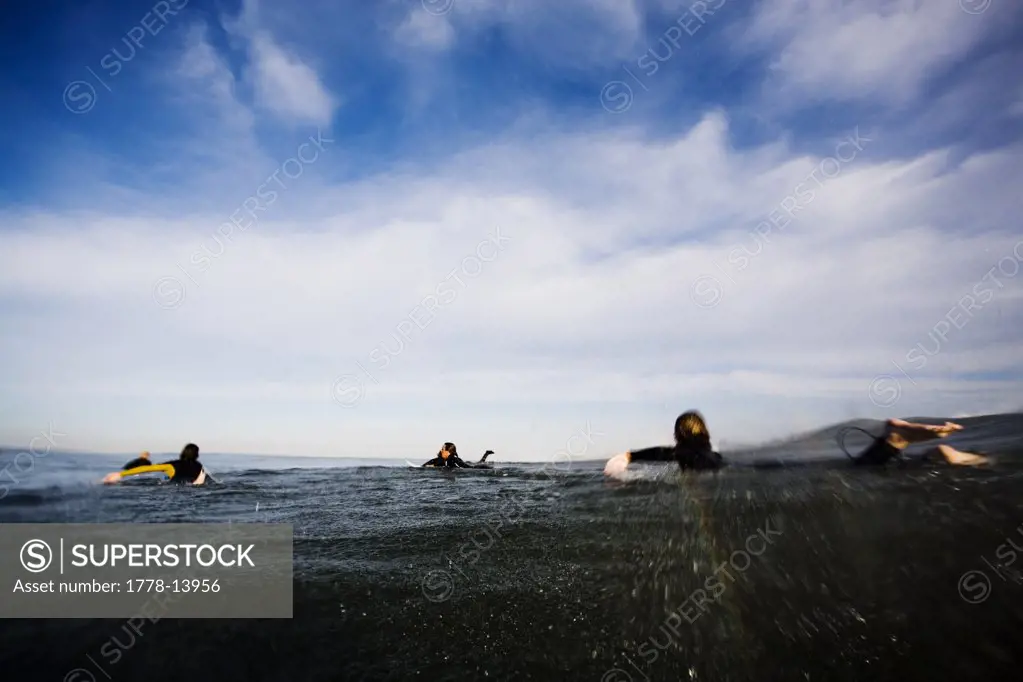 Surfers paddle out in the surf
