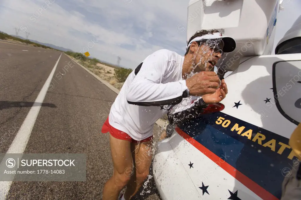 Runner getting cold water dumped on his head during a marathon in Surprise, Arizona