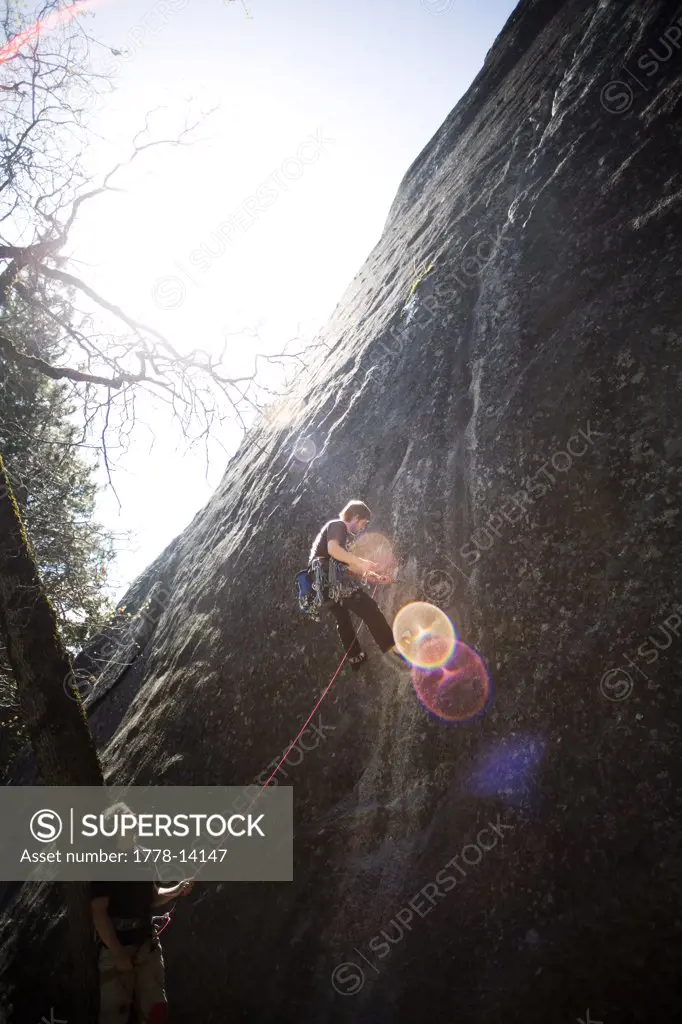 One man climbs as another belays in Yosemite, CA