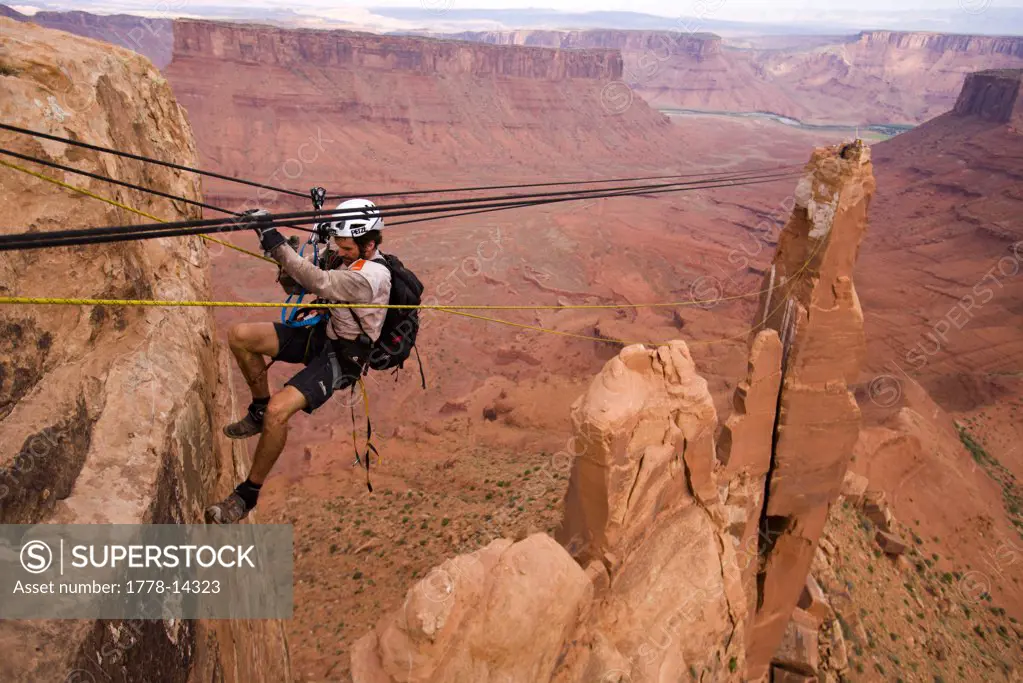 Adventure racer on a Tyrolean Traverse high above the desert in a race in Moab, Utah
