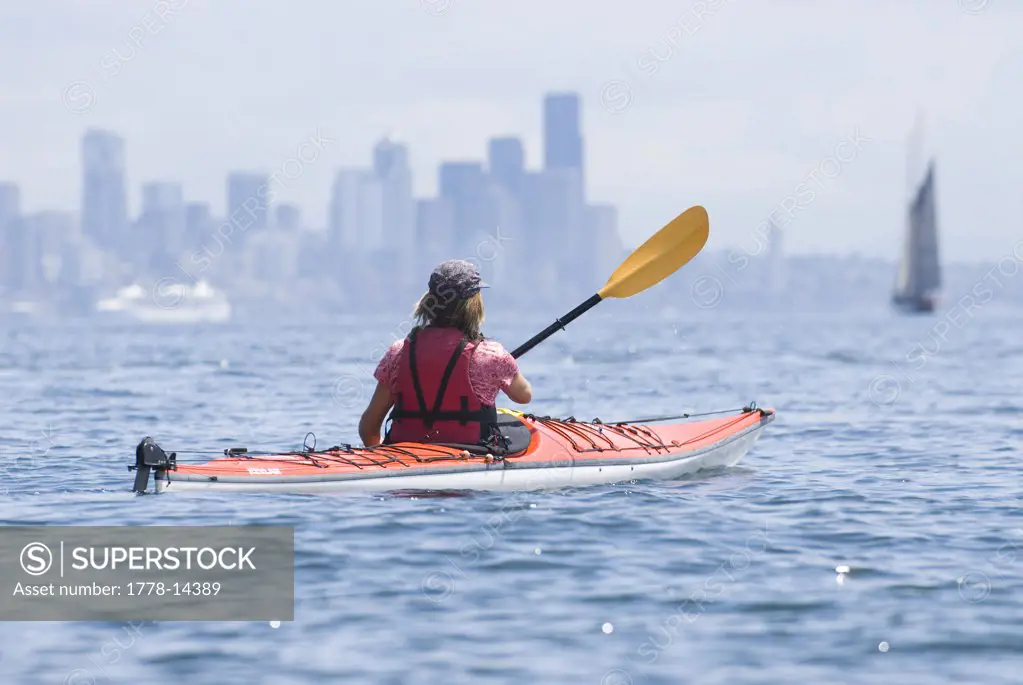 A woman kayaking in Puget Sound on June 9, 2007 with Seattle in the distance