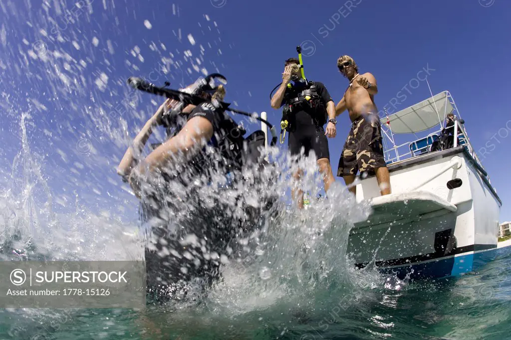 Divers enter water from rear platform of dive boat, Providenciales, Turks & Caicos