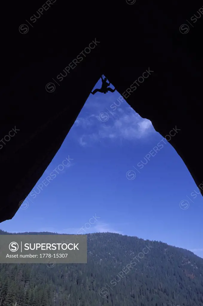 Silhouette of a climber at the top of an overhang